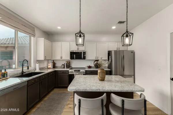 a kitchen with granite countertop a sink and refrigerator