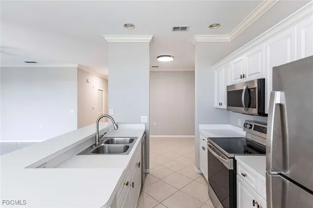 a kitchen with stainless steel appliances a refrigerator sink and microwave