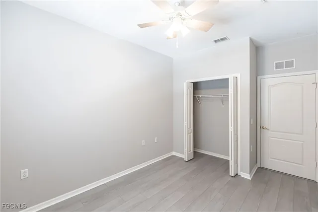 an empty room with a window and a fan