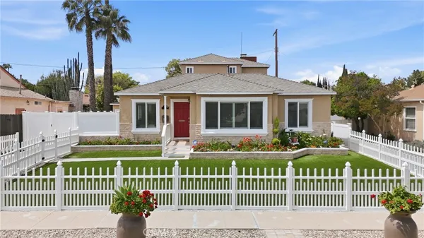 a front view of a house with a garden and plants