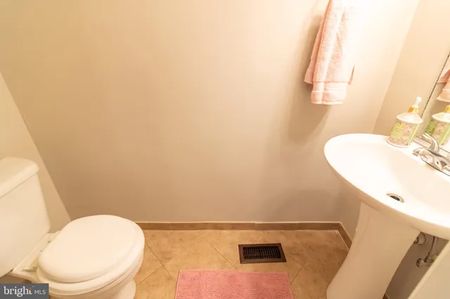 a bathroom with a sink vanity mirror and toilet