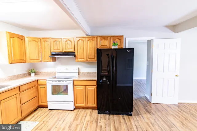 a kitchen with a sink and wooden floor
