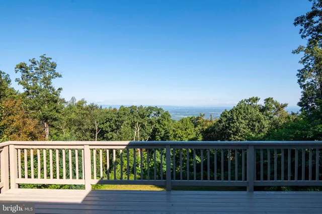 a view of a balcony with wooden floor and outdoor seating