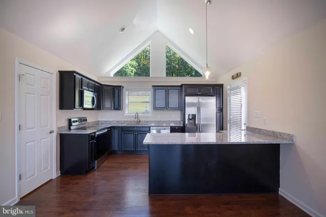 a bathroom with a granite countertop toilet a sink and a mirror