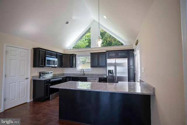 a bathroom with a granite countertop sink mirror and toilet