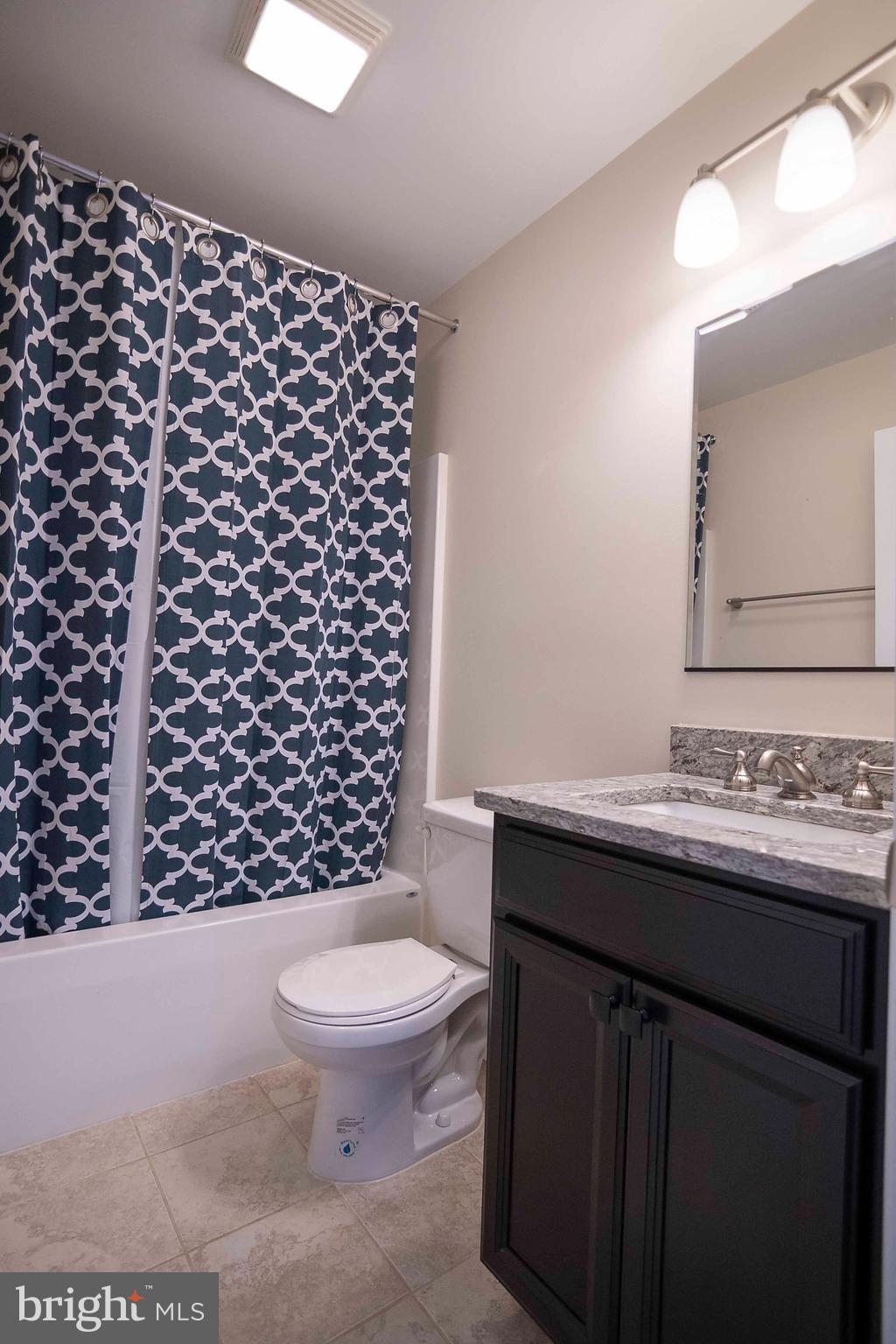 4871 Blue Mountain Road Linden, VA 22642 - Photo 41 of 73 a bathroom with a granite countertop toilet a sink and a mirror