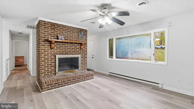 a view of an empty room with a fireplace and a window