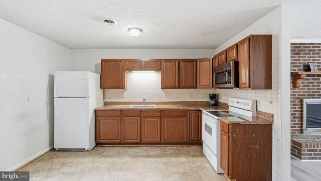 a kitchen with stainless steel appliances granite countertop a refrigerator sink stove and microwave