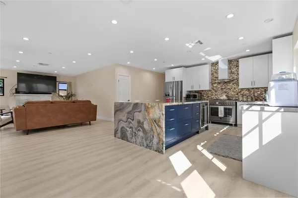 a large kitchen with stainless steel appliances lots of counter space and windows