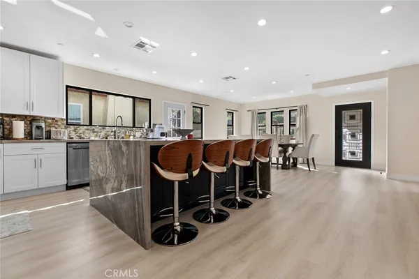 a kitchen with stainless steel appliances kitchen island granite countertop a refrigerator and cabinets