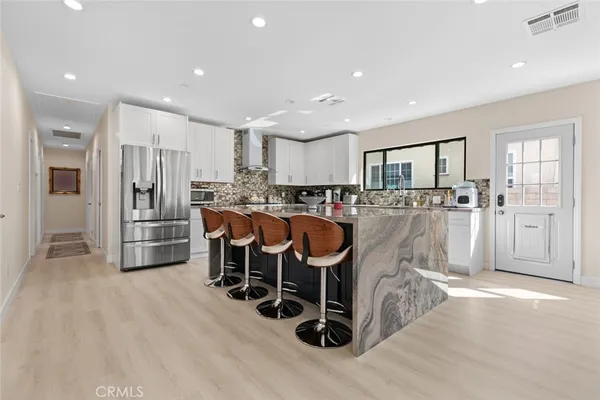 a kitchen with stainless steel appliances granite countertop a sink refrigerator and cabinets
