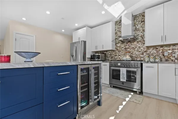 a kitchen with stainless steel appliances kitchen island granite countertop a dining table chairs and granite counter tops