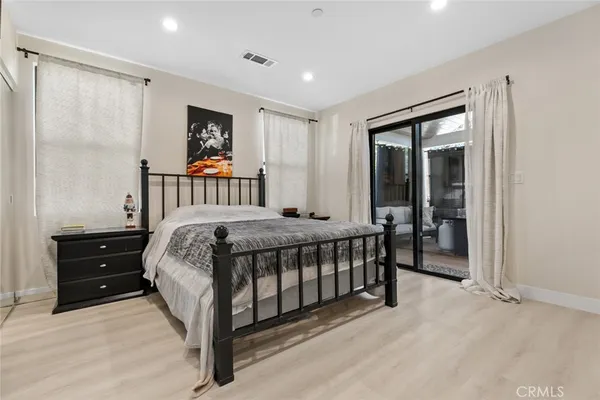 a bedroom with a large bed and a chandelier