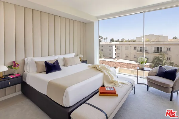 a bedroom with furniture and a large window