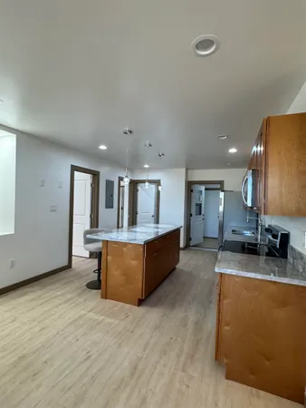 a large living room with stainless steel appliances kitchen island granite countertop a large counter top and couch