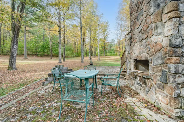 a view of a bench in a backyard with large tree