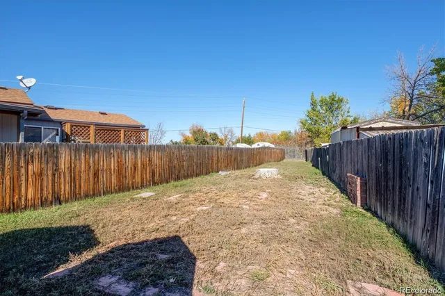 a view of a backyard with wooden fence