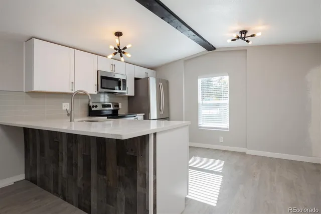 a kitchen that has a microwave a sink and a stove in it