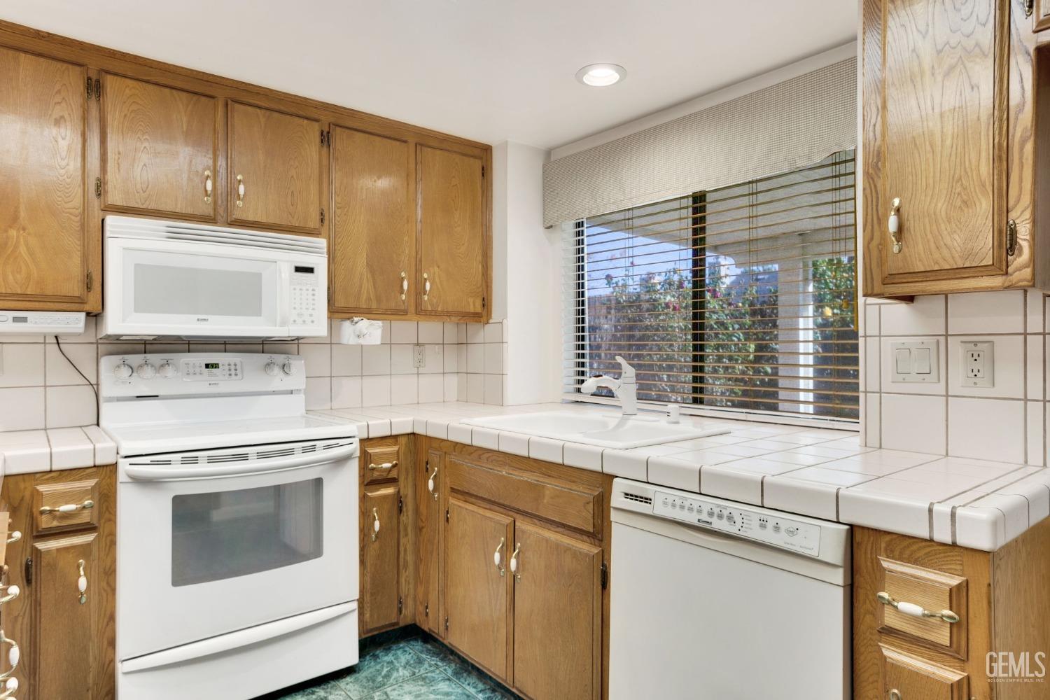 Undisclosed Address Bakersfield, CA 93311 - Photo 15 of 44 a kitchen with a sink stove and cabinets