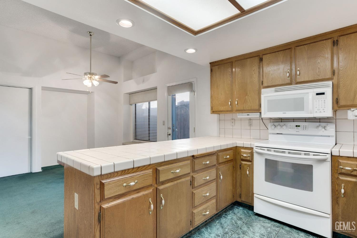 Undisclosed Address Bakersfield, CA 93311 - Photo 16 of 44 a kitchen with white cabinets and white appliances