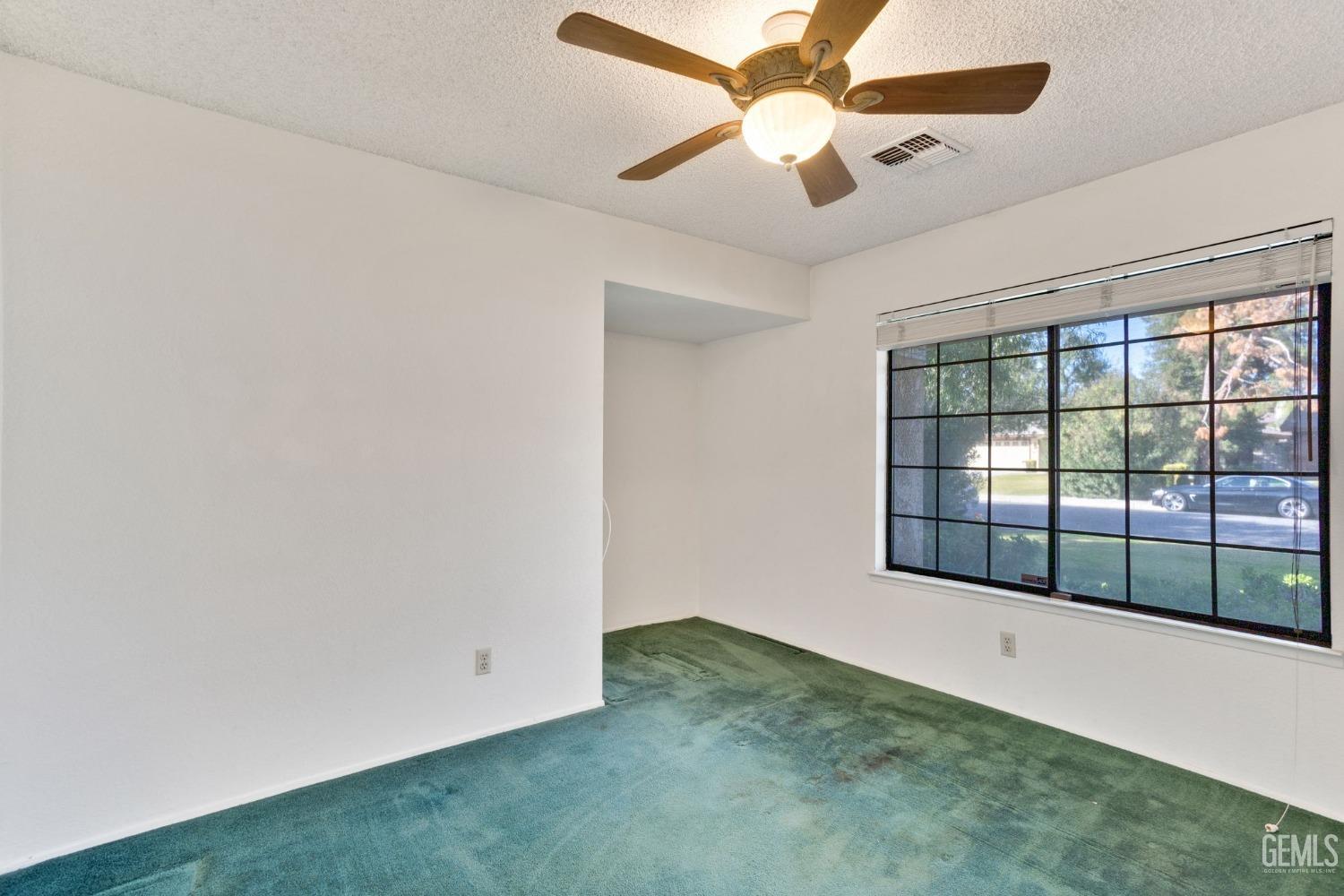 Undisclosed Address Bakersfield, CA 93311 - Photo 20 of 44 an empty room with windows and ceiling fan