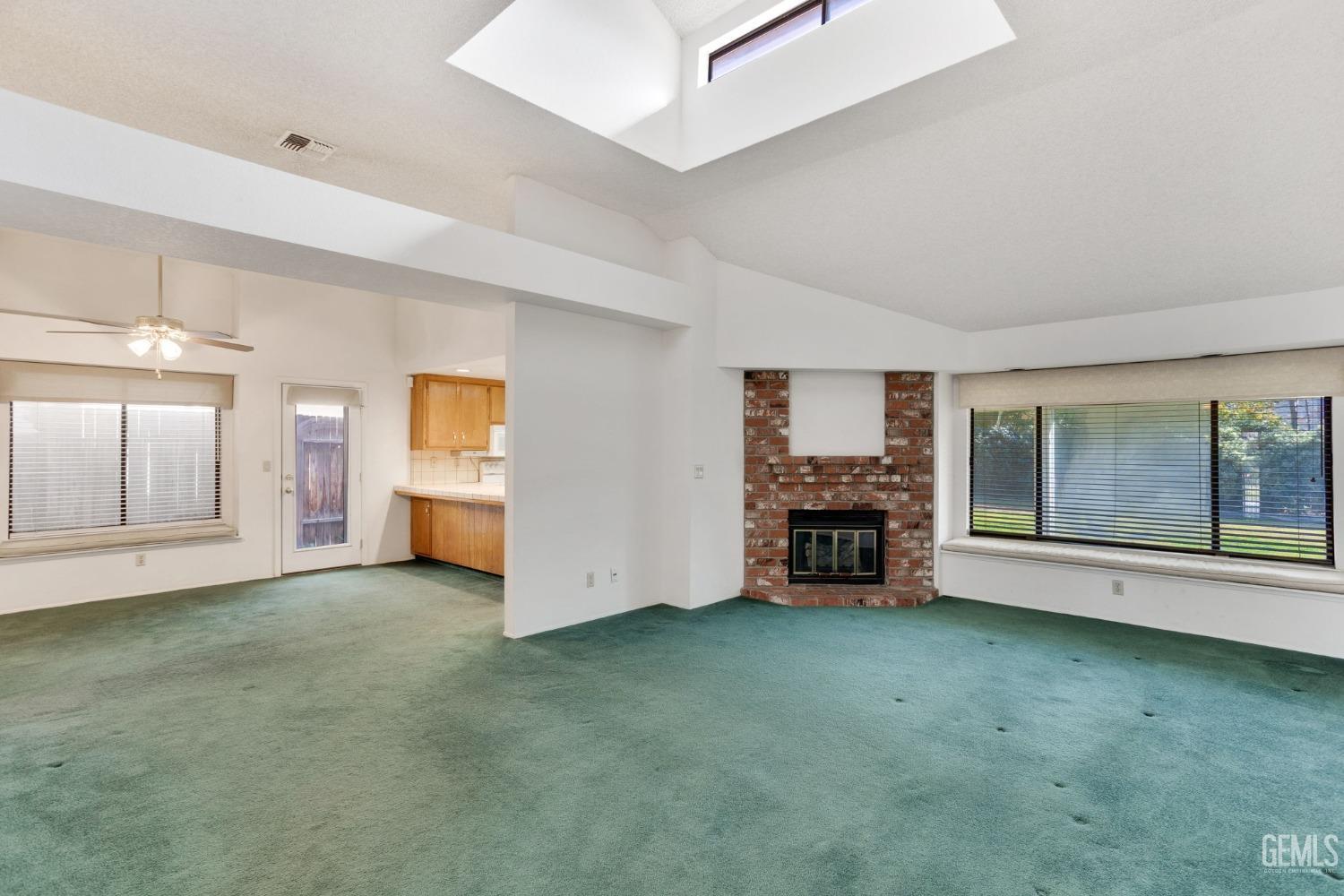 Undisclosed Address Bakersfield, CA 93311 - Photo 8 of 44 a view of an empty room with a fireplace and a window