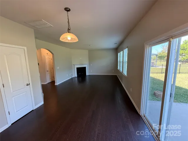 a view of a room with wooden floor and windows