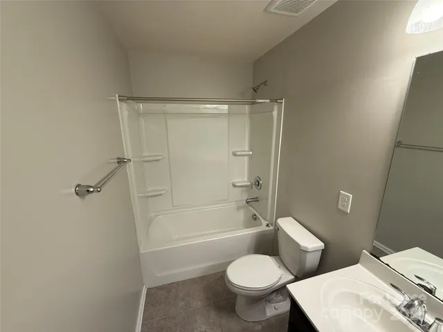 a white toilet sitting next to a bath tub
