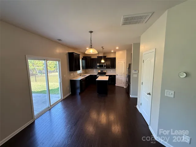 a view of a living room and kitchen with furniture wooden floor