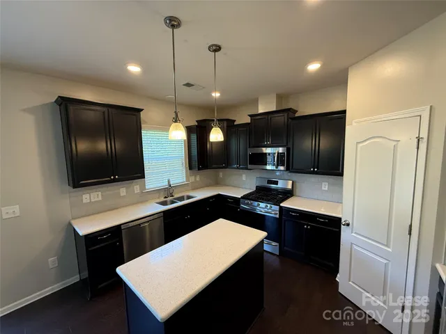 a kitchen with stainless steel appliances a sink stove and refrigerator