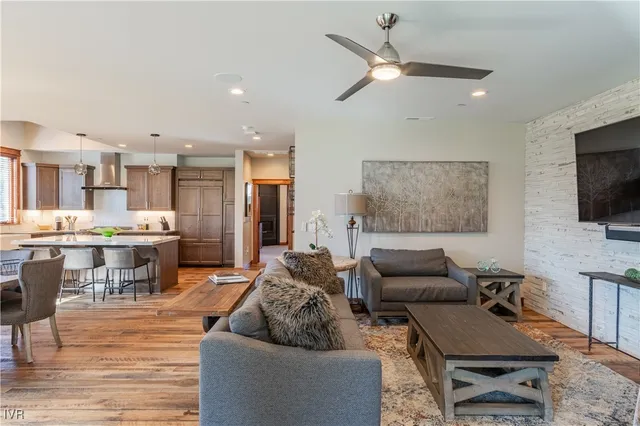 a living room with furniture and a flat screen tv with kitchen view
