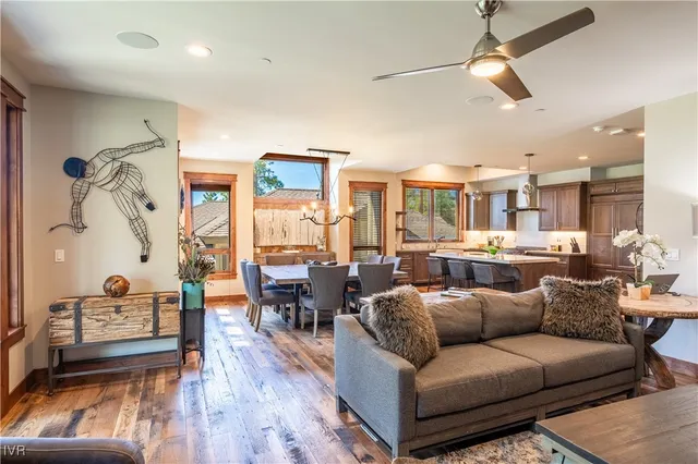 a living room with furniture kitchen view and a wooden floor