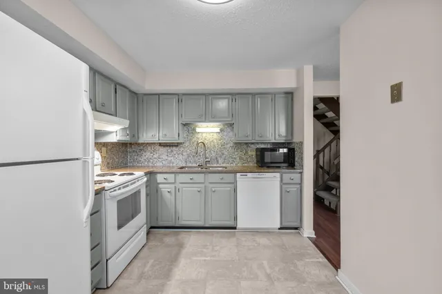 a kitchen with stainless steel appliances granite countertop a refrigerator sink and stove