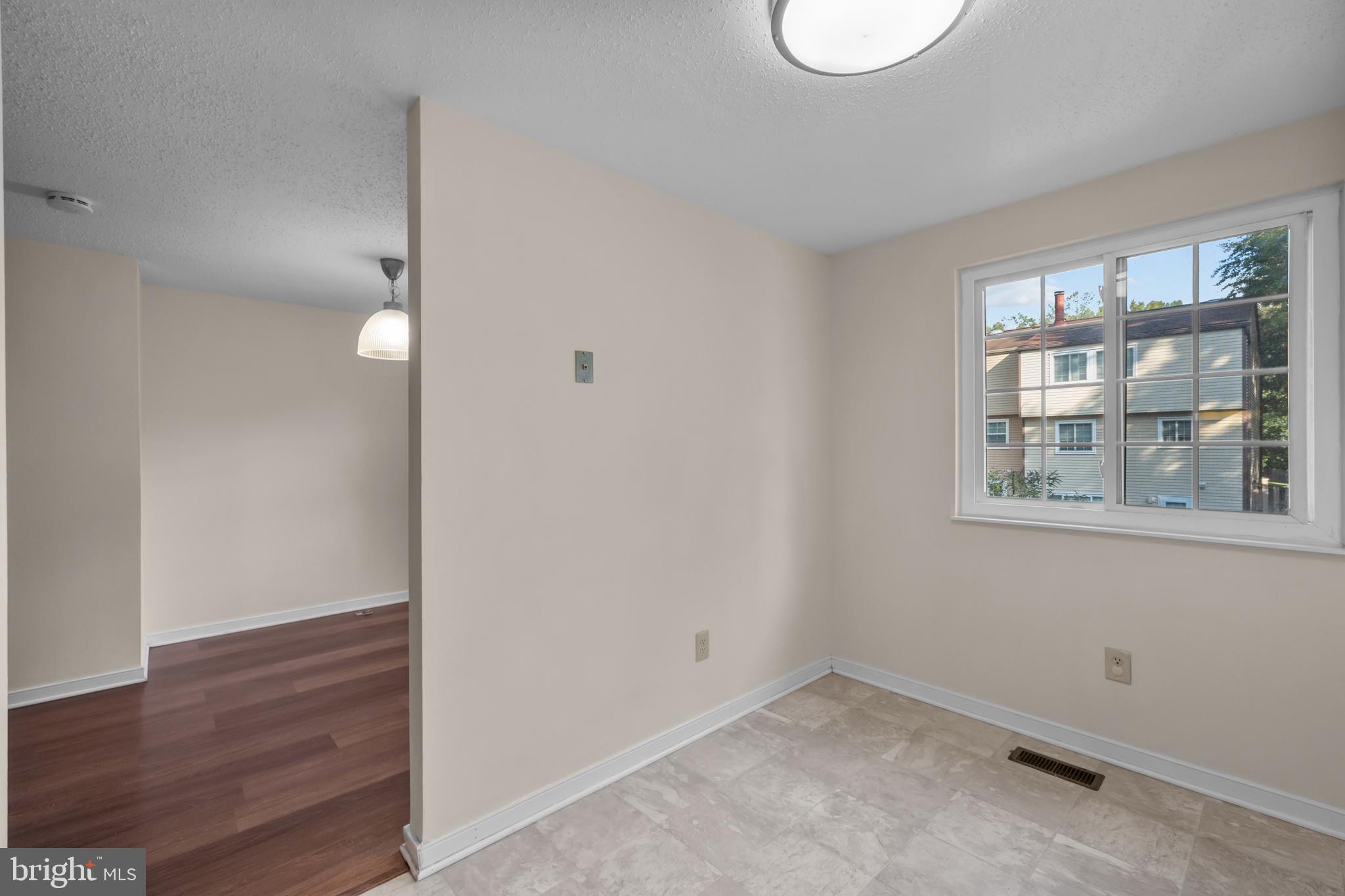 6832 Heatherway Court Alexandria, VA 22315 - Photo 12 of 37 a view of an empty room with wooden floor and a window