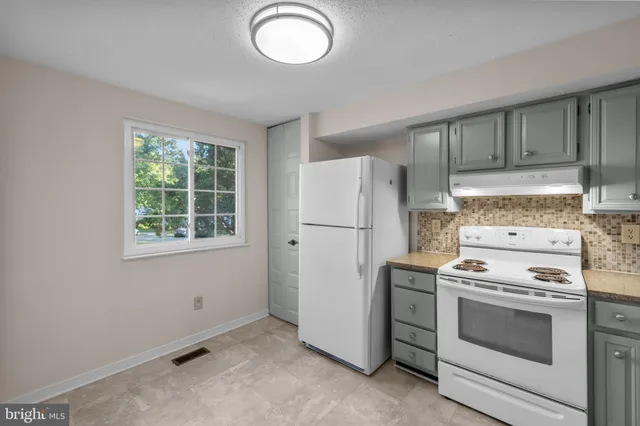 a kitchen with a stove top oven and refrigerator