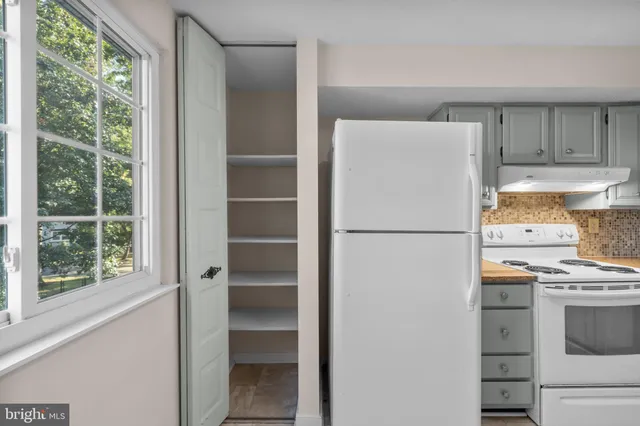 a white refrigerator freezer and a stove sitting inside of a kitchen