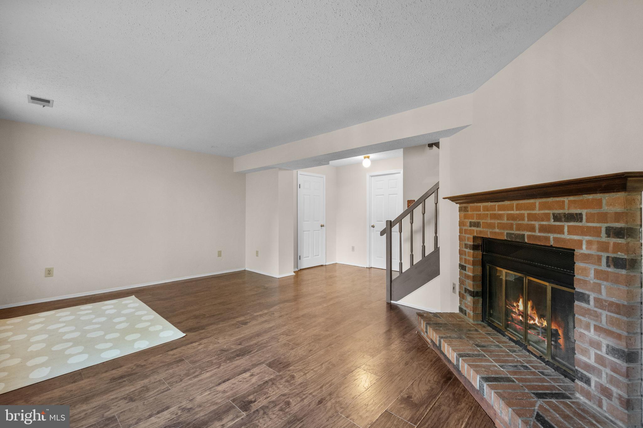 6832 Heatherway Court Alexandria, VA 22315 - Photo 28 of 37 a view of an empty room with wooden floor fireplace and a window