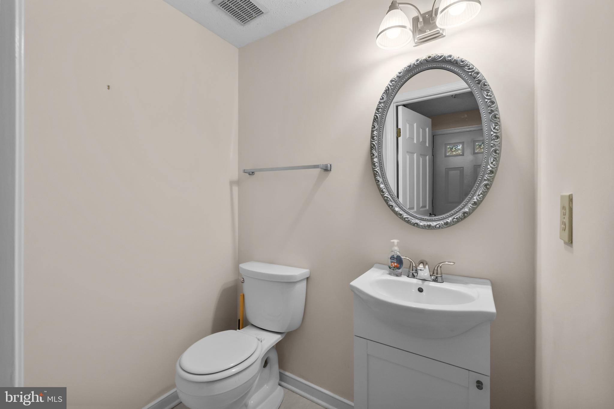 6832 Heatherway Court Alexandria, VA 22315 - Photo 31 of 37 a bathroom with a toilet sink and mirror