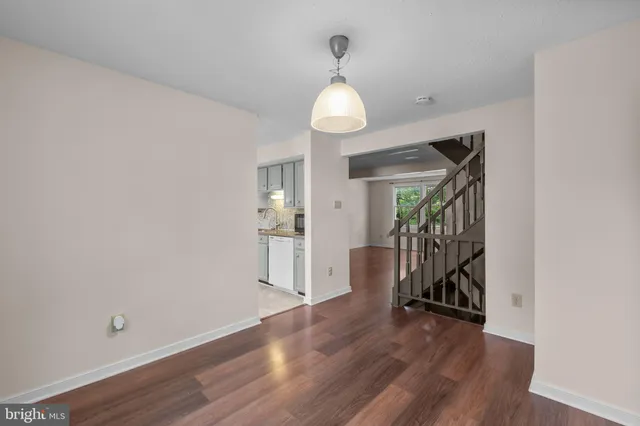 a view of a room with wooden floor staircase and a chandelier