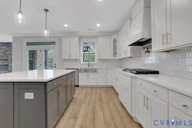 a kitchen with kitchen island granite countertop a sink a counter space appliances and cabinets