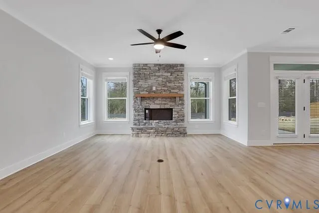 a view of empty room with wooden floor and fireplace