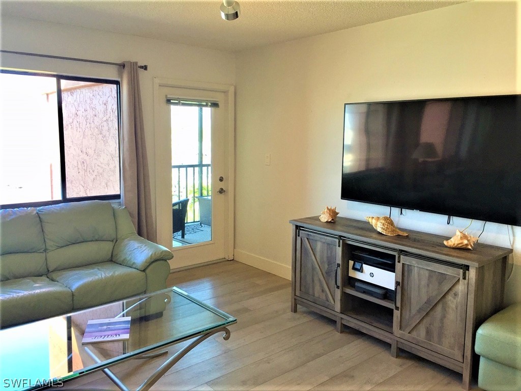 3170 Matecumbe Key Road, Unit 134 Punta Gorda, FL 33955 - Photo 23 of 41 a living room with furniture and a flat screen tv