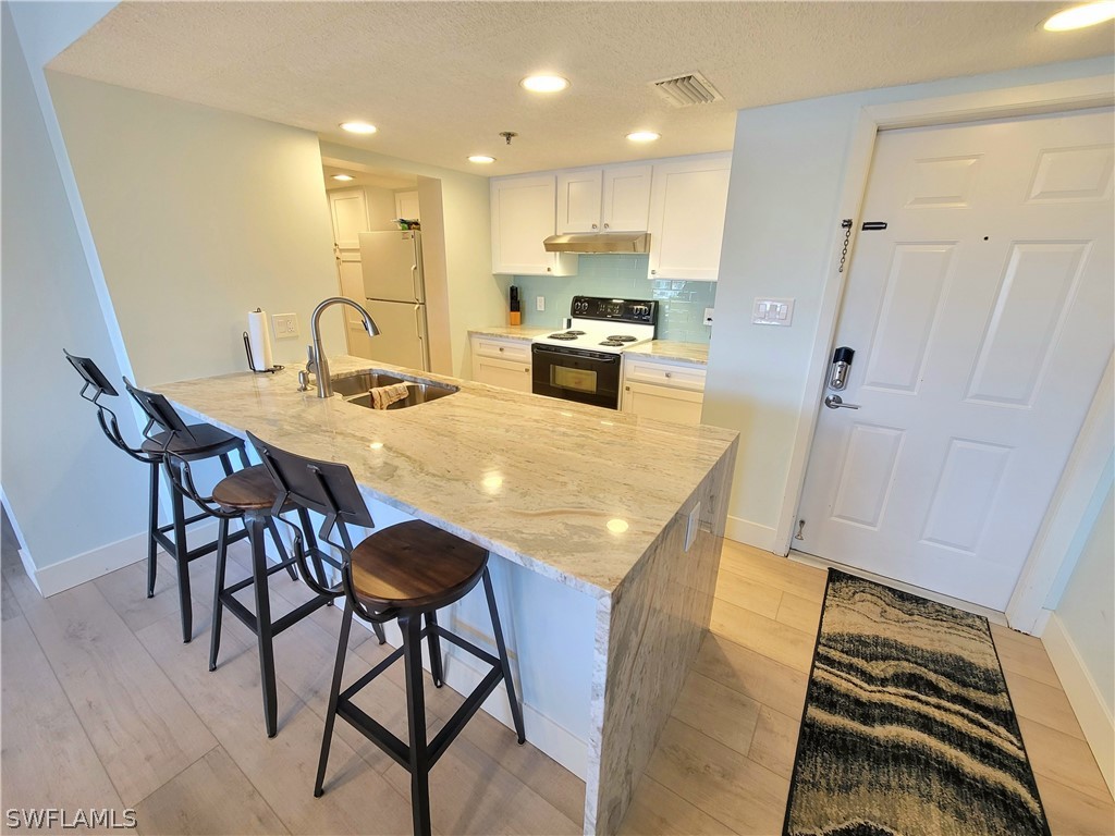 3170 Matecumbe Key Road, Unit 134 Punta Gorda, FL 33955 - Photo 8 of 41 a kitchen with a table chairs refrigerator and microwave