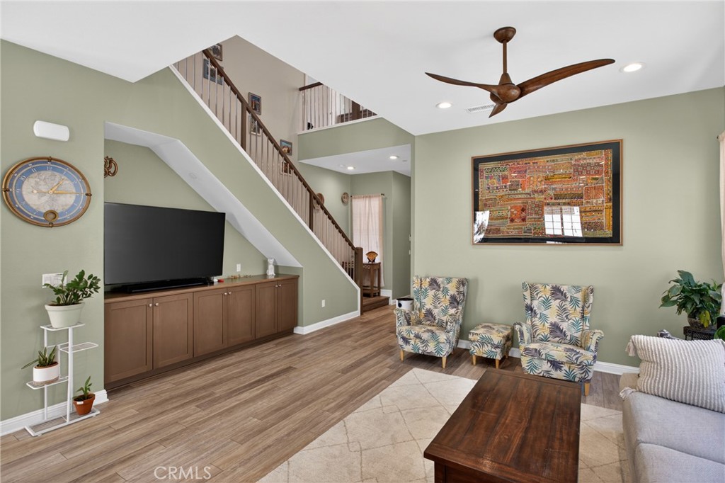 20667 West Beech Porter Ranch, CA 91326 - Photo 4 of 60 Bright and airy family room featuring soaring ceilings, upgraded flooring, custom built-in media cabinetry, and an open staircase that adds architectural character and spaciousness to the home.