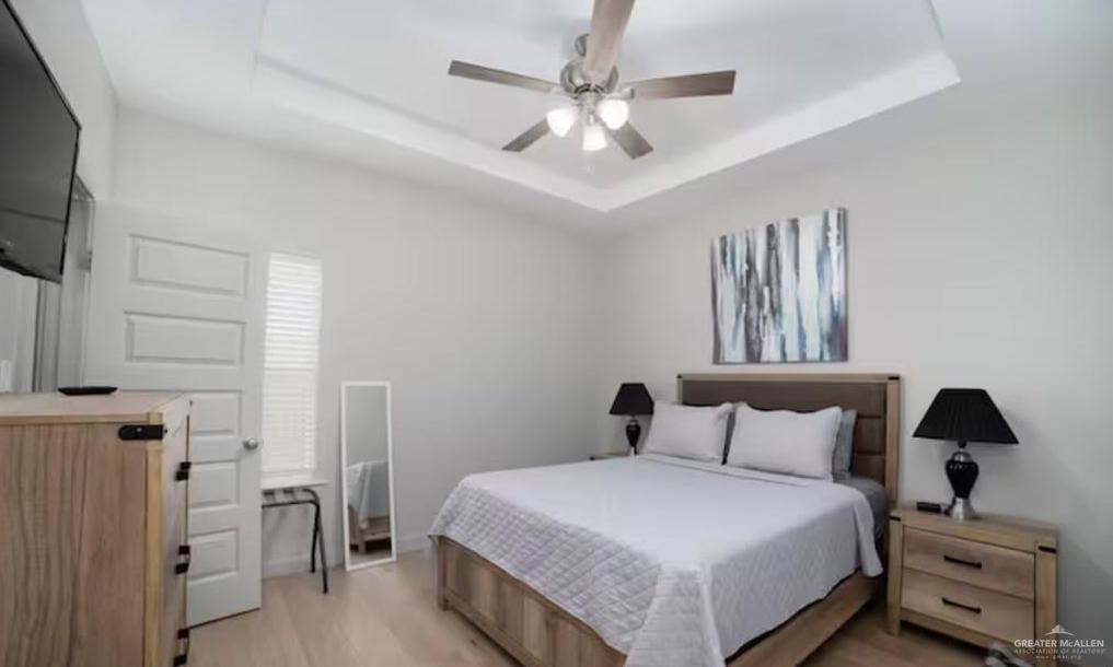2402 Treasure Cove Harlingen, TX 78550 - Photo 12 of 22 a bedroom with a bed and a flat tv screen on the dresser