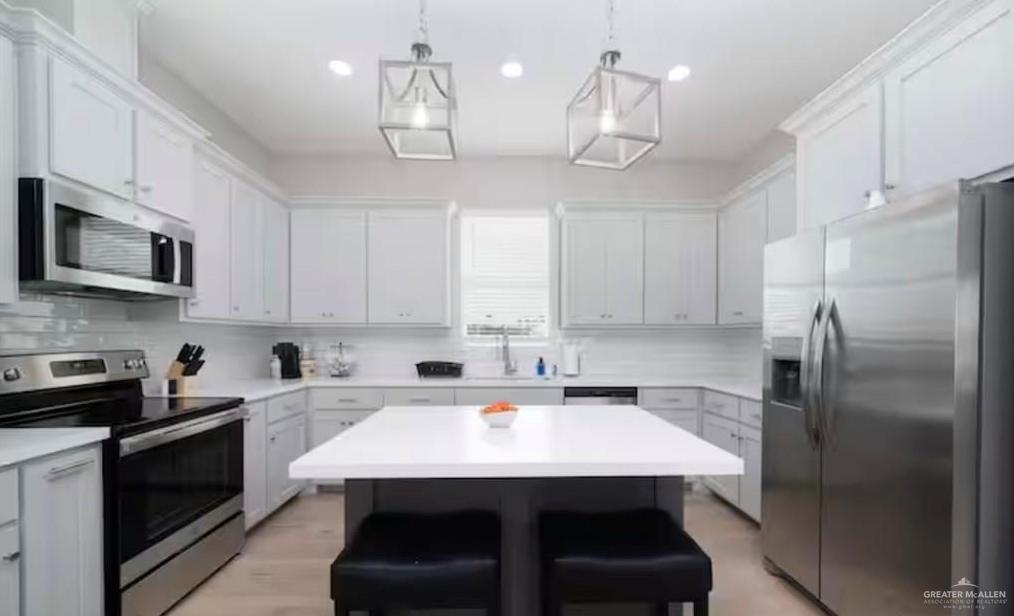 2402 Treasure Cove Harlingen, TX 78550 - Photo 20 of 22 a kitchen with stainless steel appliances a sink a microwave a refrigerator and cabinets