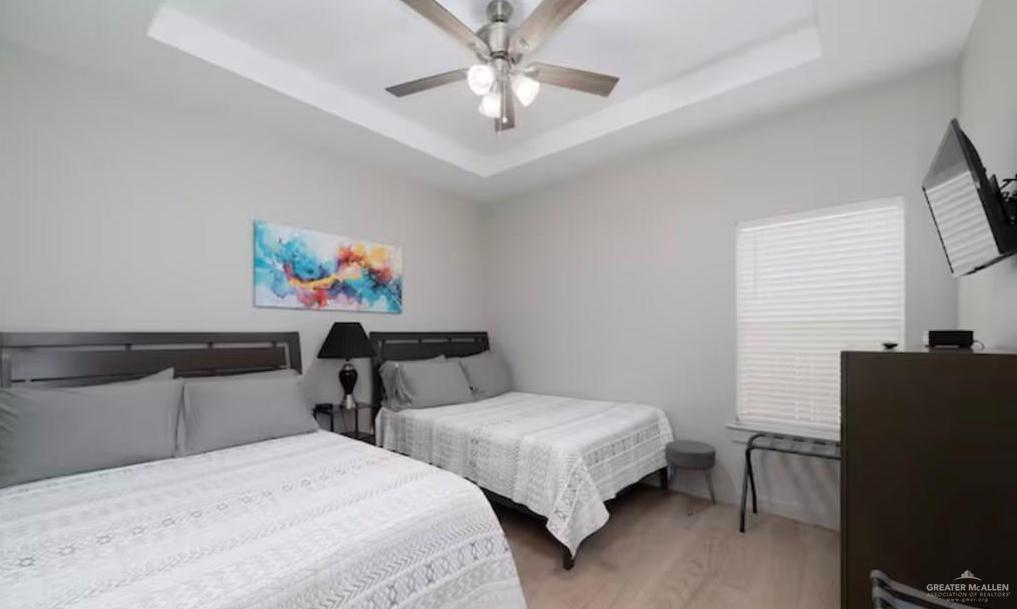 2402 Treasure Cove Harlingen, TX 78550 - Photo 8 of 22 a bedroom with two beds and a chandelier