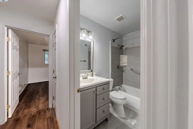 a bathroom with a granite countertop sink a toilet and shower