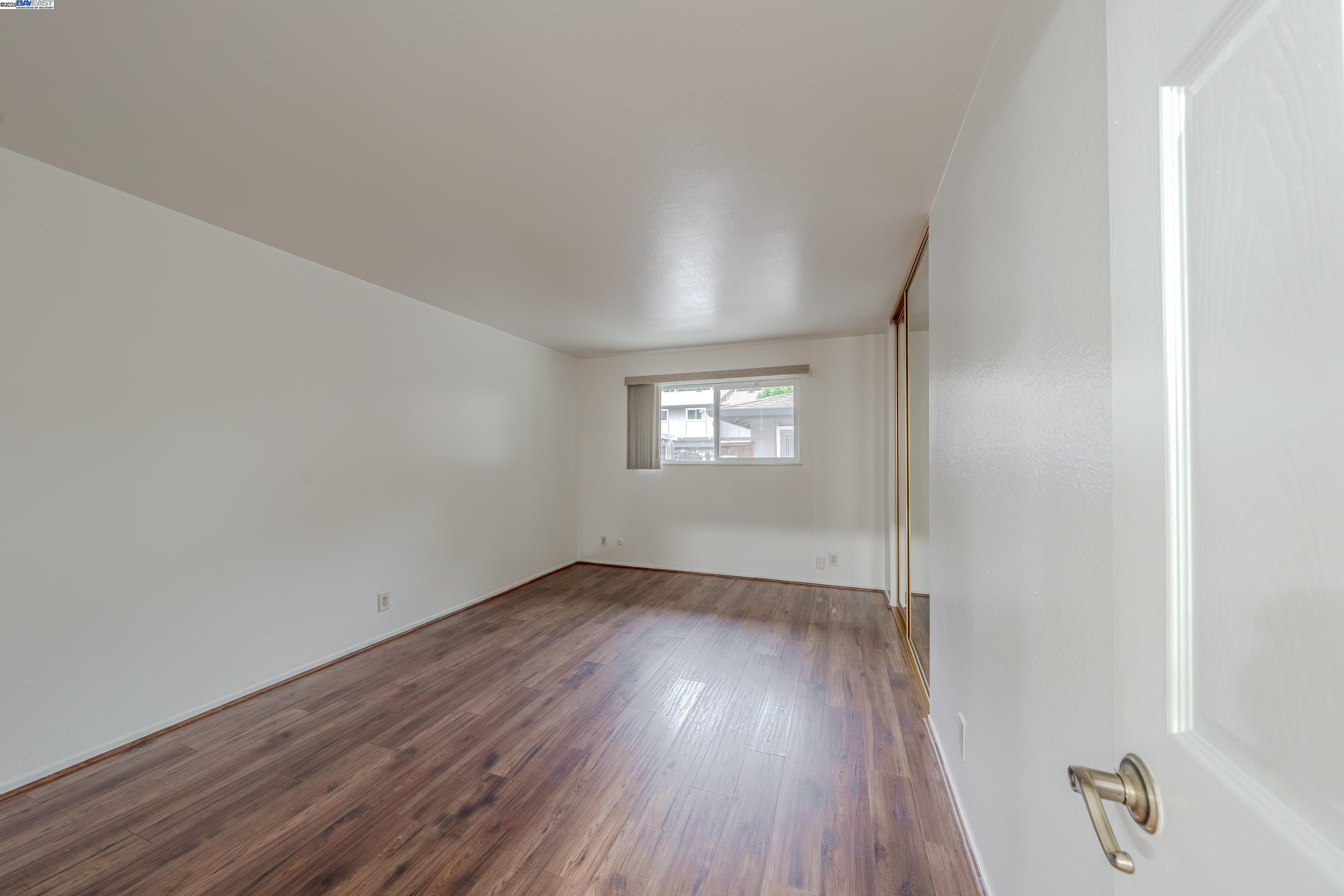 3799 Colet Terrace Fremont, CA 94536 - Photo 13 of 19 an empty room with wooden floor and windows