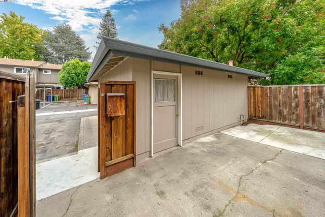 a view of backyard of house with wooden fence